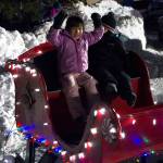 The Homer Chamber of Commerces holiday tree lighting on Dec. 2 wouldnt have been complete without a ride in Santas sleigh for these two! (Photo by Sarah Knapp/Homer News)