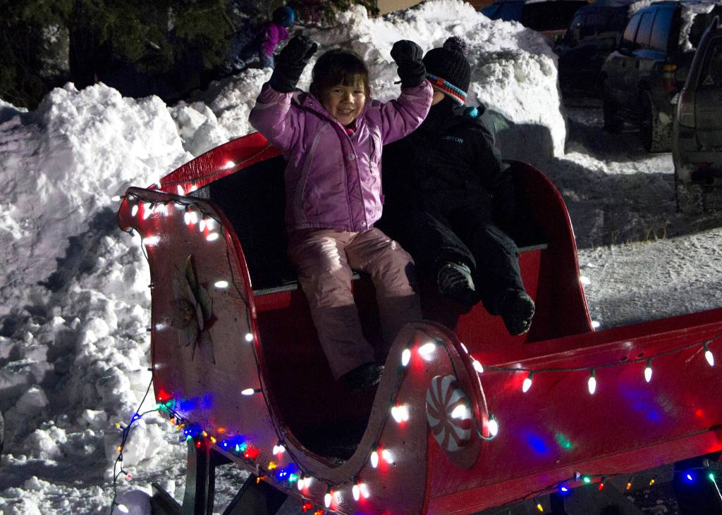 The Homer Chamber of Commerces holiday tree lighting on Dec. 2 wouldnt have been complete without a ride in Santas sleigh for these two! (Photo by Sarah Knapp/Homer News)
