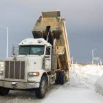 A truck dumps a load of snow recently plowed off of local streets into a lot near Public Works. (Photo by Sarah Knapp/Homer News)