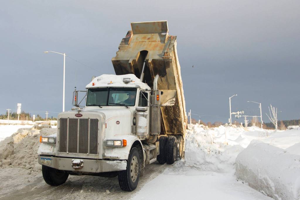 A truck dumps a load of snow recently plowed off of local streets into a lot near Public Works. (Photo by Sarah Knapp/Homer News)