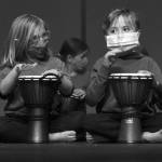 Photo by Sarah Knapp/Homer News 
Two first graders drum along with Sankofa Dance Theater Alaska during their end of residency performance.