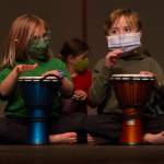 Two first graders drum along with Sankofa Dance Theater Alaska during their end of residency performance. (Photo by Sarah Knapp/Homer News)