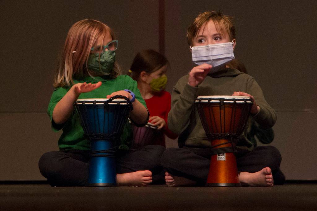 Two first graders drum along with Sankofa Dance Theater Alaska during their end of residency performance. (Photo by Sarah Knapp/Homer News)