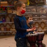A Fireweed Academy kindergartener follows the beat set by Sankofa Dance Theatre performers on Dec. 9. (Photo by Sarah Knapp/Homer News)