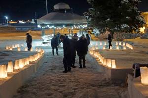 People look at memorial luminarias on Thursday, Dec. 16, 2021, for Hospice of Homer's "LIght Up a Life" event at WKFL Park in Homer, Alaska. (Photo by Michael Armstrong/Homer News)
