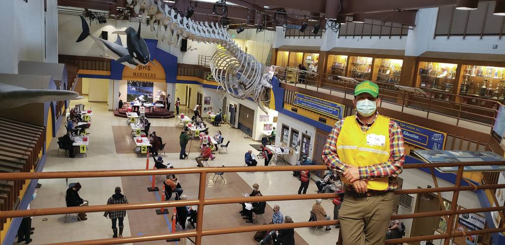 City of Homer Recreation Manager Mike Illg, who is in the planning section of Homers Unified Command Mass Vaccination PODs, stands on the upper level of Homer High School overlooking the Commons during a vaccine clinic on Friday, March 5, 2021 in Homer, Alaska. Providing more than 500 doses of the COVID-19 vaccine to local residents, it was the Unified Commands largest mass clinic to date. (Photo courtesy Derotha Ferraro/South Peninsula Hospital)