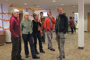 Artist Asia Freeman, third from left, speaks to visitors at a First Friday art exhibit opening featuring pieces by students in a college class she teaches, on Friday, Nov. 1, 2019, at Kachemak Bay Campus in Homer. (Photo by Megan Pacer/Homer News)