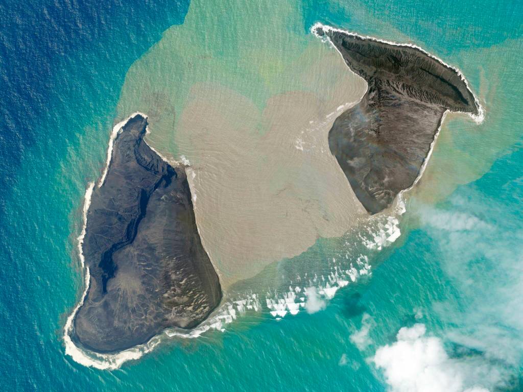 In this satellite photo taken by Planet Labs PBC, an island created by the underwater Hunga Tonga Hunga Ha'apai volcano is just before a massive eruption Saturday, Jan. 15, 2022. An undersea volcano erupted in spectacular fashion near the Pacific nation of Tonga on Saturday, sending large tsunami waves crashing across the shore and people rushing to higher ground. A tsunami advisory was in effect for Hawaii, Alaska and the U.S. Pacific coast, with reports of waves pushing boats up in the docks in Hawaii. (Planet Labs PBC via AP)