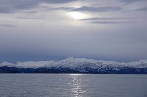 Clouds obscure the sun on Monday, Jan. 18, 2022, as seen from the Mariner Park beach in Homer, Alaska. Yukon Island is in the distance. Almost a month after the winter solstice, the sun rises higher in the sky at mid-day. (Photo by Michael Armstrong/Homer News)