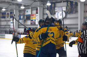 Mariners Casey Otis is rushed by his team after scoring against the Houston Hawks, with an assist by Hunter Green. The Mariners won 4-3 in overtime Friday night. (Photo by Sarah Knapp/Homer News)