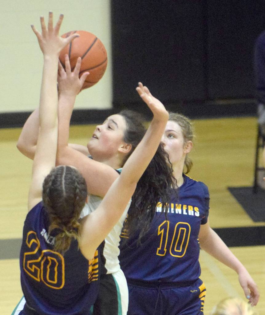 Nikiskis Kailey Stynsberg goes up for a basket between Homers Mel Morris and Bethany Engebretsen on Tuesday, Jan. 25, 2022, at Nikiski High School in Nikiski, Alaska. (Photo by Jeff Helminiak/Peninsula Clarion)