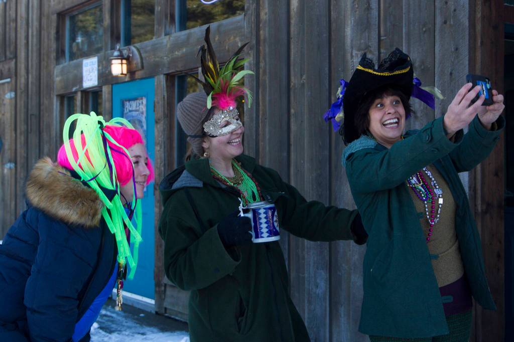 These three ladies are all smiles for the Krewe of Gambrinus Winter Carnival and Mardi Gras parade. (Photo by Sarah Knapp/Homer News)
