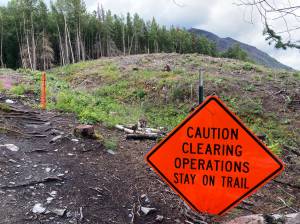 A sign urging caution stands on the Slaughter Ridge Trail in an area cleared to make way for the Cooper Landing Bypass, on Aug. 10 in Cooper Landing, Alaska. (Photo by Jeff Helminiak/Peninsula Clarion)