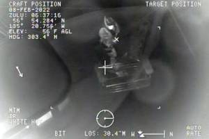 A Coast Guard rescue swimmer pulls in a rescue basket during an emergency call to a stricken vessel south of Sitka on Feb. 7, 2022. (Screenshot)