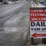 A sign at the corner of Pioneer Avenue and Bartlett Street points the way to the South Peninsula Hospital COVID-19 testing and vaccine clinic on Bartlett Street on Feb. 17, 2021, in Homer, Alaska. (Photo by Michael Armstrong/Homer News)