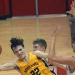 Ninilchik's Justin Trail saves the ball in front of Kenai Central's Luke Armstrong and Eli McCubbins on Saturday, March 5, 2022, at Kenai Central High School in Kenai, Alaska. (Photo by Jeff Helminiak/Peninsula Clarion)