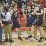 The Homer boys basketball team celebrates earning a state berth Saturday, March 12, 2022, at the Peninsula Conference tournament at Kenai Central High School in Kenai, Alaska. (Photo by Jeff Helminiak/Peninsula Clarion)