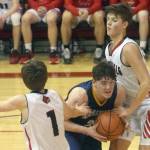 Homers Carter Tennison splits Kenai Centrals Ky Calvert and Eli McCubbins on Saturday, March 12, 2022, at the Peninsula Conference tournament at Kenai Central High School in Kenai, Alaska. (Photo by Jeff Helminiak/Peninsula Clarion)