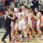 The Kenai Central girls basketball team celebrates clinching a state berth Saturday, March 12, 2022, at the Peninsula Conference tournament at Kenai Central High School in Kenai, Alaska. (Photo by Jeff Helminiak/Peninsula Clarion)
