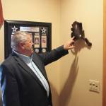Charlie Pierce points to an award he received for service at ENSTAR Natural Gas Company at his home on Thursday, March 11, 2022 in Sterling, Alaska. (Ashlyn OHara/Peninsula Clarion)