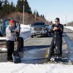 It takes a cosmic village Kachemak Nordic Ski Club volunteers Roy Wilson, left, and Carl Brinkerhoff, right, keep a snow bridge over Diamond Ridge Road in shape for skiers competing in the Kachemak Marathon race on Saturday, March 19, 2022, in Homer, Alaska. (Photo by Michael Armstrong/Homer News)