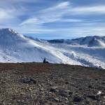 A hiker rests near the peak of Near Point Trail in Anchorage, Alaska, on March 20, 2022. (Camille Botello/Peninsula Clarion)