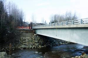 The new Anchor River Bridge spans the river next to the road to the old bridge, as see on Thursday, April 9, 2022, in Anchor Point, Alaska. (Photo by Michael Armstrong/Homer News)