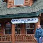 Real estate agent Jena Petersen stands in front of Seward Real Estate Company in Seward, Alaska, on Tuesday, May 3, 2022. (Camille Botello/Peninsula Clarion)