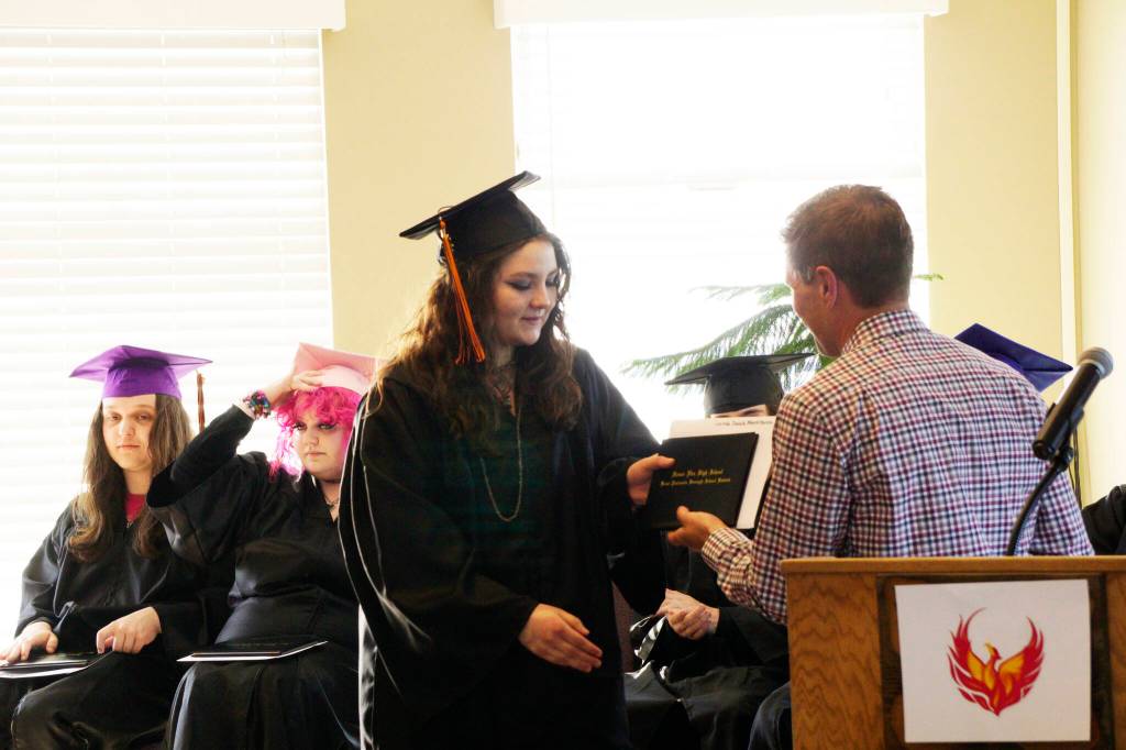 Homer Flex graduate Lucinda Maryott Moreno receives her diploma from Homer Flex Principal Christopher Brown, right, at graduation ceremonies on Wednesday, May 18, 2022, at Lands End Resort in Homer, Alaska. (Photo by Michael Armstrong/Homer News)