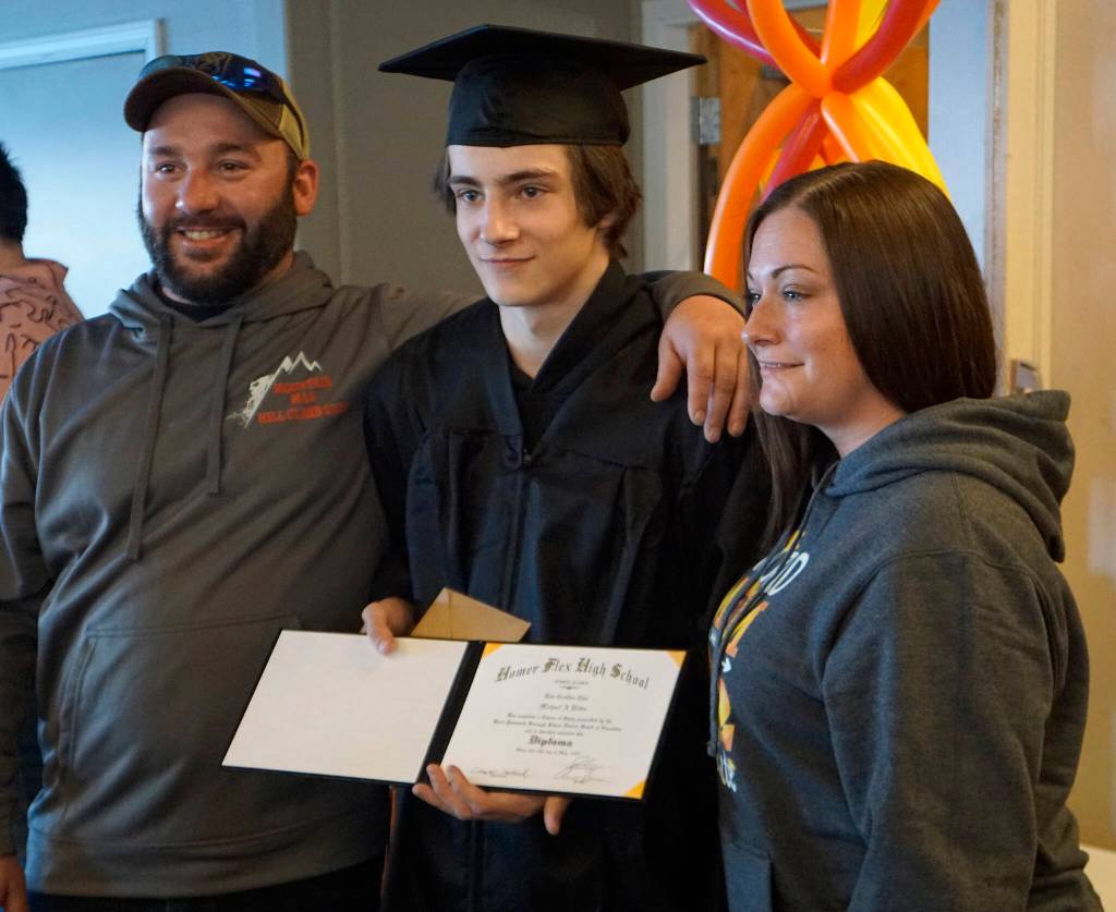 Flex School graduate Michael Ritter, center, poses with his parents, Andrew Roderick, left, and Katrina Roderick, right, after graduation ceremonies on Wednesday, May 18, 2022, at Lands End Resort in Homer, Alaska. (Photo by Michael Armstrong/Homer News)