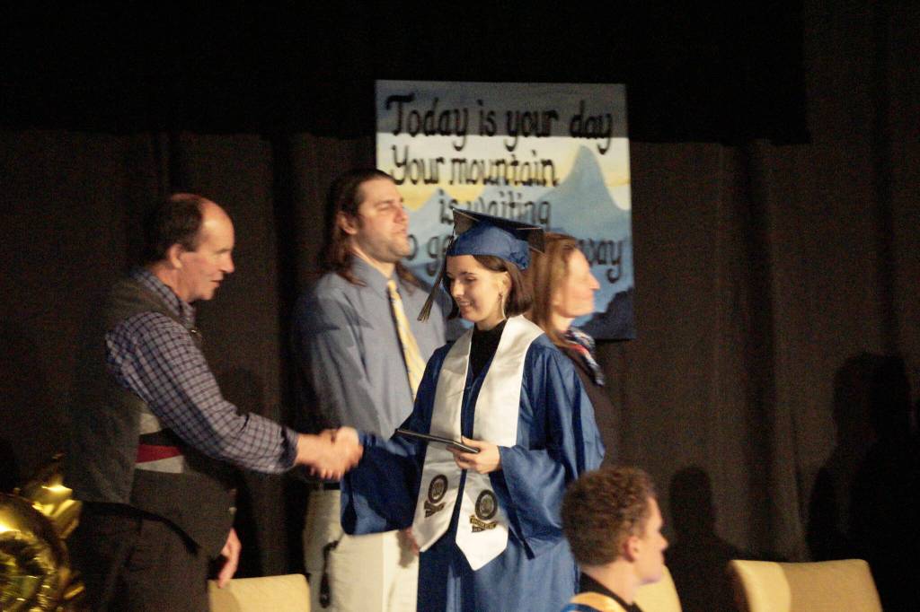 Mariah McGuire shakes the hand of Kenai Peninsual Board School Board member Tim Daugharty at Homer High School graduation exercises in the Alice Witte Gymnasium for commencement on Wednesday, May 18, 2022, at Homer High School in Homer, Alaska. (Photo by Michael Armstrong/Homer News)
