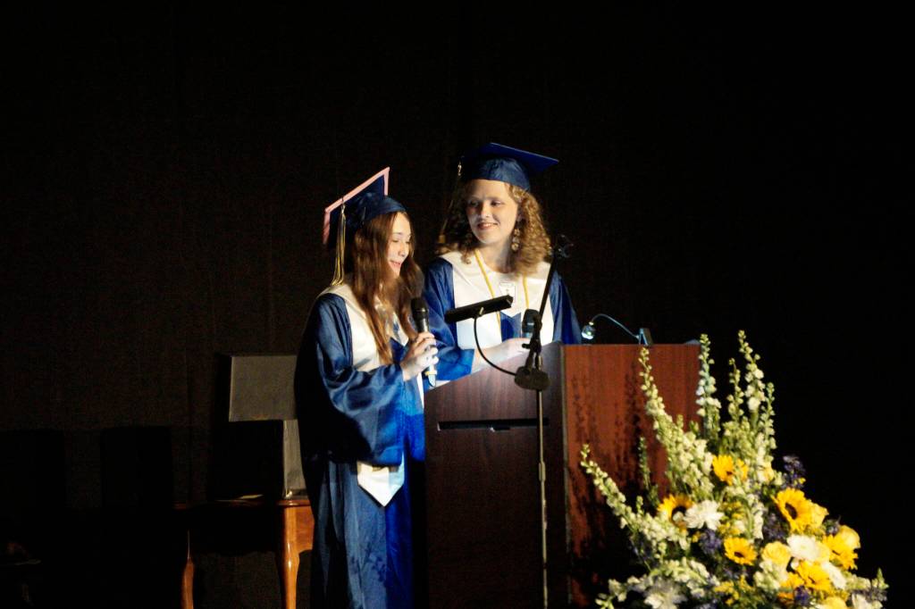 Valedictorians Serena Fankhauser, left, and Olivia Glasman, right, deliver their address at Homer High School graduation in the Alice Witte Gymnasium on Wednesday, May 18, 2022, at Homer High School in Homer, Alaska. (Photo by Michael Armstrong/Homer News)