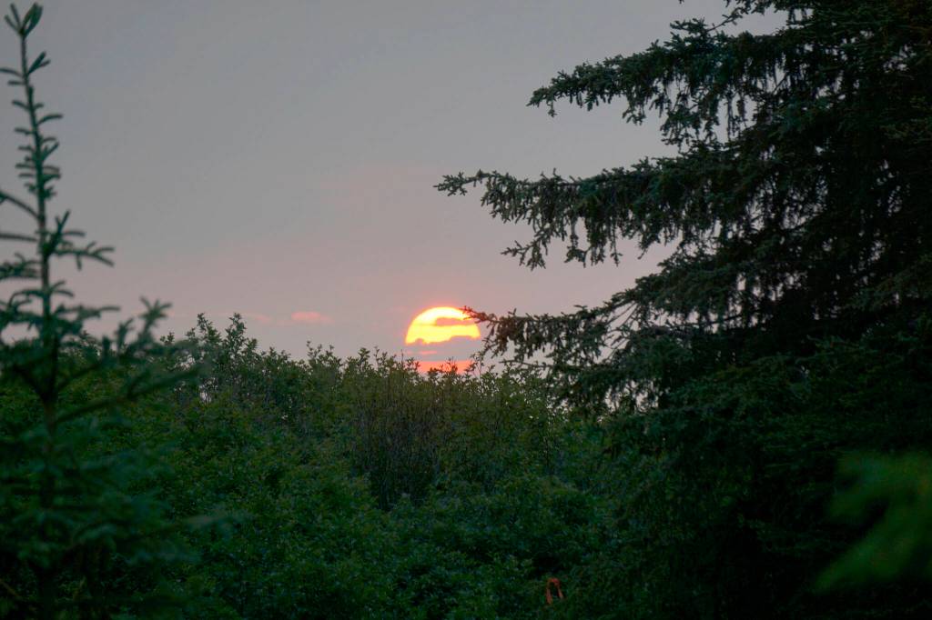 Smoke from wildfires makes the setting sun appear bright red on Saturday, June 11, 2022, as seen from Diamond Ridge near Homer, Alaska. (Photo by Michael Armstrong/Homer News)