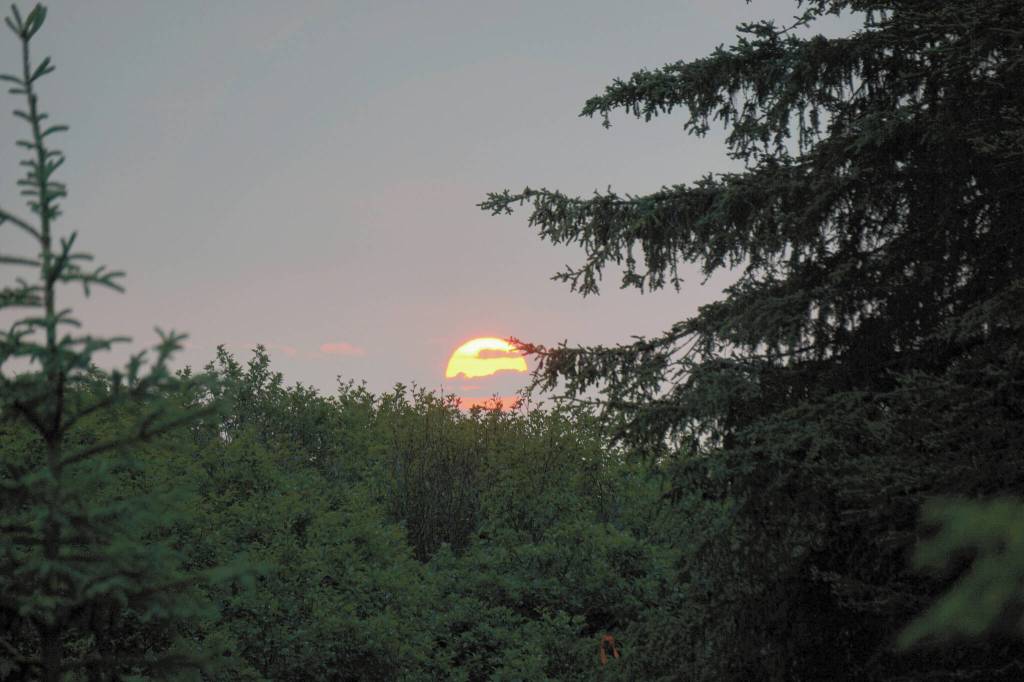 Smoke from wildfires makes the setting sun appear bright red on Saturday, June 11, 2022, as seen from Diamond Ridge near Homer, Alaska. (Photo by Michael Armstrong/Homer News)