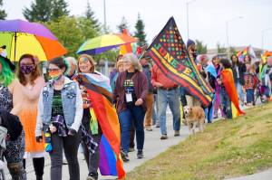 Marchers wearing Pride rainbow colors and carrying Juneteenth flags march in the Pride-X-Juneteenth parade on Saturday, June 18, 2022, on Pioneer Avenue in Homer, Alaska. (Photo by Michael Armstrong/Homer News)