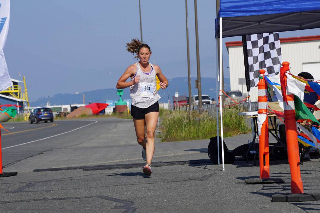 Aleah Mickelson, the first-place woman in the 2022 Homer Spit Run Half Marathon, crosses the finish line on Saturday, June 25, 2022, at the End of the Road Park in Homer, Alaska. (Photo by Michael Armstrong/Homer News)