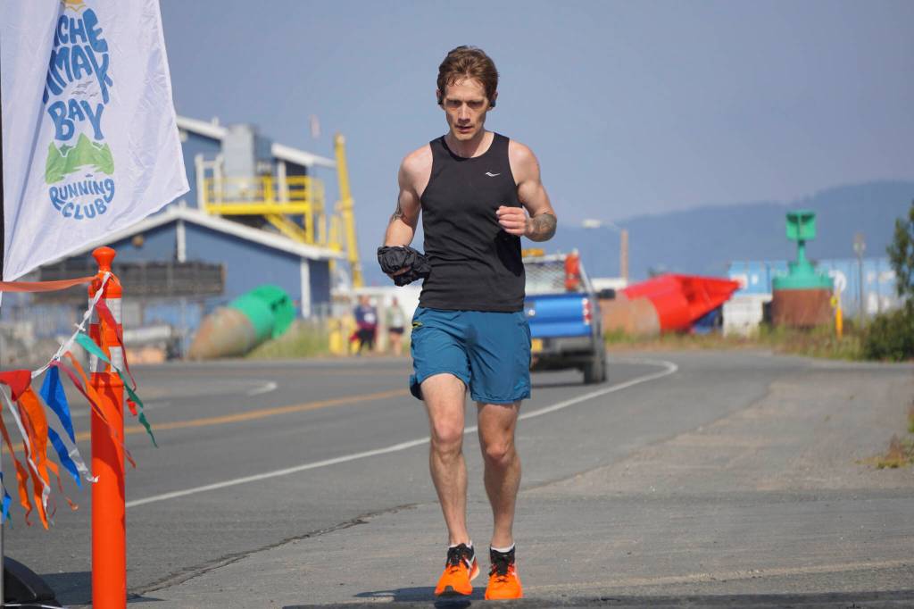 Tim Robinson, the first-place man in the 2022 Homer Spit Run Half Marathon, crosses the finish line on Saturday, June 25, 2022, at the End of the Road Park in Homer, Alaska. (Photo by Michael Armstrong/Homer News)