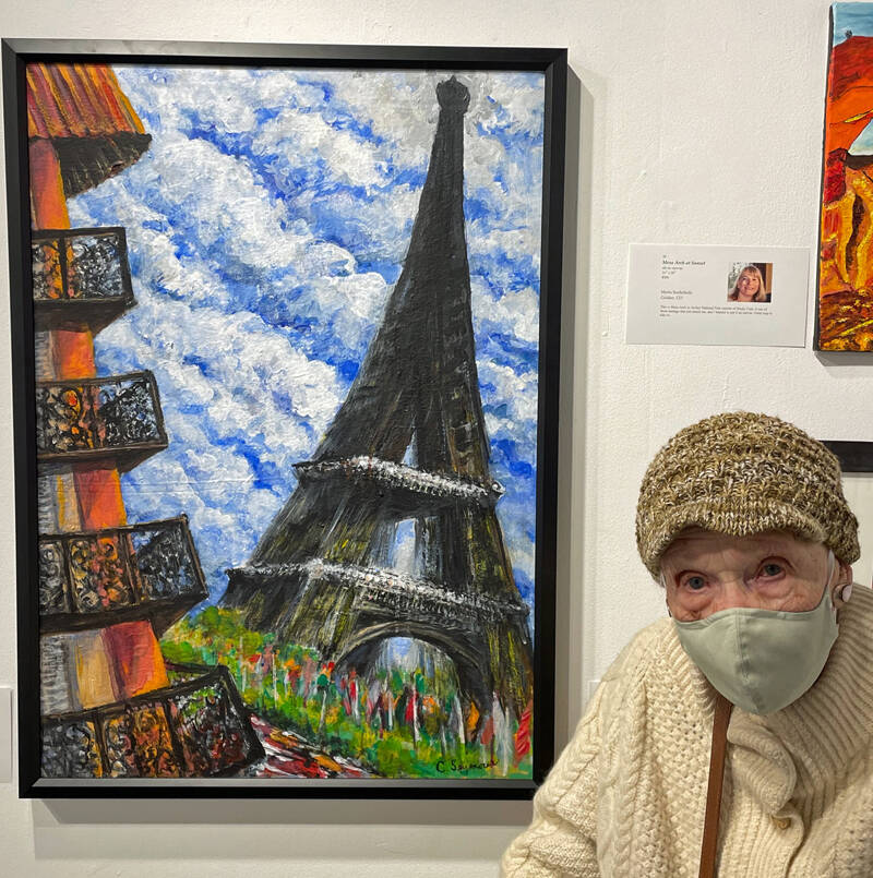 Carolyn Seymour poses next to one of her paintings. She shows her work Friday and Saturday, July 8-9, 2022, at Ptarmigan Arts in Homer, Alaska. The show honors Seymour, Ptarmigans oldest artist, who turned 100 in May. (Photo provided)