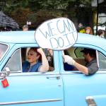 A woman dressed as Rosey the Riveter drives a 1953 Ford restored by Bill Sheldon for the Tails and Tassels Burlesque group  the winner of the Best Car group  during the Homer Fourth of July parade on Monday, July 4, 2022, on Pioneer Avenue in Homer, Alaska. (Photo by Michael Armstrong/Homer News)