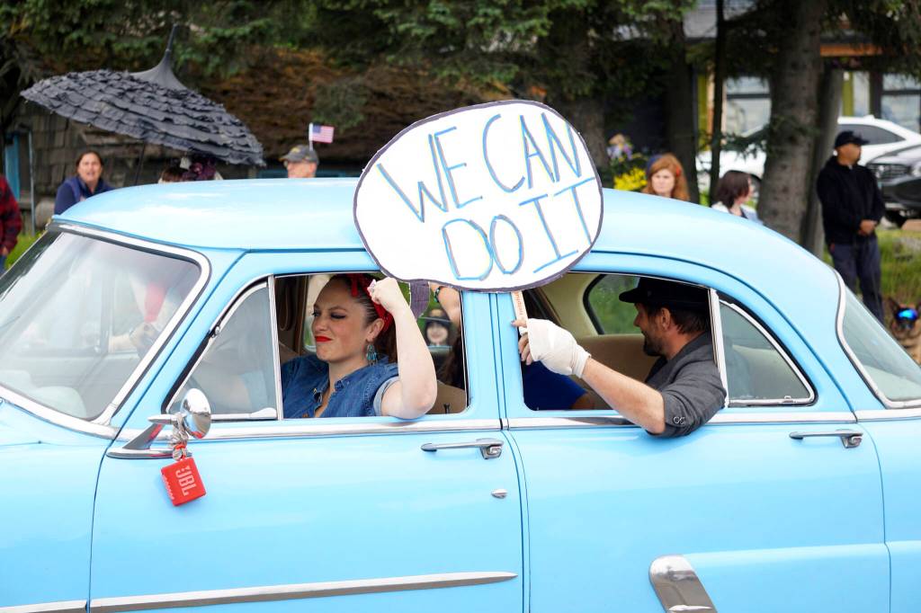 A woman dressed as Rosey the Riveter drives a 1953 Ford restored by Bill Sheldon for the Tails and Tassels Burlesque group  the winner of the Best Car group  during the Homer Fourth of July parade on Monday, July 4, 2022, on Pioneer Avenue in Homer, Alaska. (Photo by Michael Armstrong/Homer News)