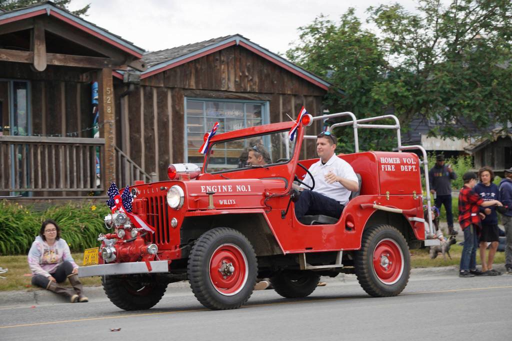 A man drives the Homer Volunteer Fire Departments Engine No. 1 Willys Jeep during the Homer Fourth of July parade on Monday, July 4, 2022, on Pioneer Avenue in Homer, Alaska. (Photo by Michael Armstrong/Homer News)