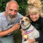 Greg and Teresa Groeneweg pose with their dog Ace, who is wearing a life saver medal Greg received from the Anchorage Fire Department years ago. He said Ace deserves it now more than him, for fighting off a bear. (Courtesy Greg Groeneweg)