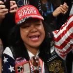 Mimi Israelah, center, cheers for Donald Trump inside the Alaska Airlines Center in Anchorage, Alaska, during a rally Saturday July 9, 2022. An investigation has been launched after a person believed to be an Anchorage, Alaska, police officer was shown in a photo with Israelah flashing a novelty White Privilege card. The social media post caused concerns about racial equality in Alaskas largest city. (Bill Roth / Anchorage Daily News)