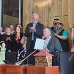 Gov. Mike Dunleavy, center, holds a copy of House Bill 123, providing state recognition for Alaskas 229 federally recognized Native tribes, at an event hosted by the Alaska Federation of Natives in Anchorage, Alaska, on Thursday, July 28, 2022. (Photo provided by the Alaska Federation of Natives)