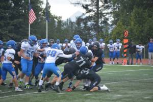 The Mariner defensive unit sacks the Kodiak quarterback at its game on Saturday, Aug. 13, 2022, at Homer High School in Homer, Alaska. (Photo by Charlie Menke/ Homer News)