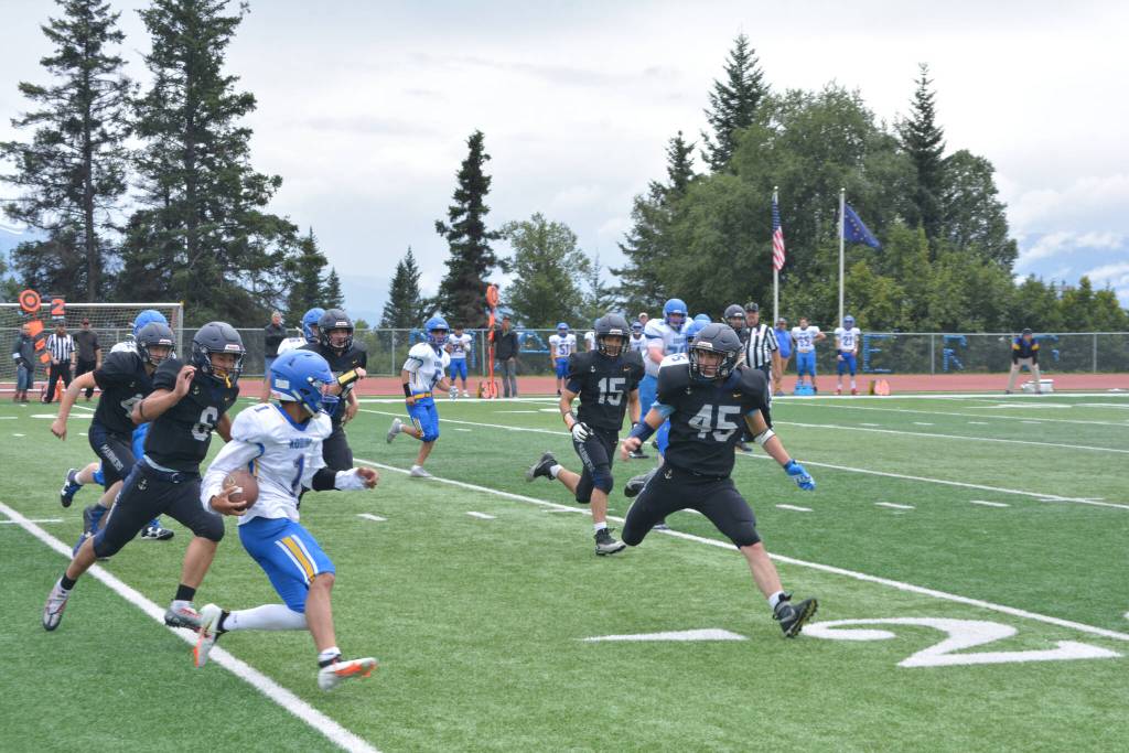 Mariners suffocate the Kodiak runner, led by Bernie Black on Saturday, Aug. 13, 2022, at Homer High School in Homer, Alaska. (Photo by Charlie Menke/ Homer News)