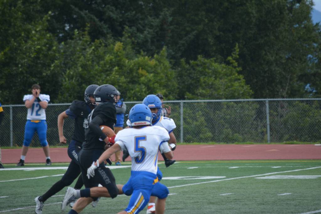 Tappan busts through the center of the field on Saturday, Aug. 13, 2022, at Homer High School in Homer, Alaska. (Photo by Charlie Menke/ Homer News)