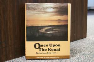 A copy of Once Upon the Kenai: Stories from the People rests against a desk inside the Peninsula Clarions offices on Wednesday, Aug. 3, 2022, in Kenai, Alaska. (Ashlyn OHara/Peninsula Clarion)