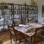 At an open house for the Storyknife Writers Retreat on Monday, Aug. 29, 2022, Storyknife board member Patty Stith looks at one of the books published by past Storyknife fellows in the library of Eva, the main house for the retreat near Homer, Alaska. (Photo by Michael Armstrong/Homer News)