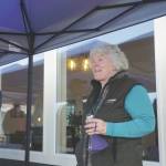Storyknife Writers Retreat founder and writer Dana Stabenow speaks on the deck of Eva, the main cabin of the complex, at an open house on Monday, Aug. 29, at the retreat near Homer. At left is Dave Girard, one of the carpenters who worked on the project and built the custom dining table for Eva.